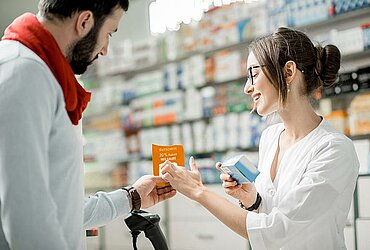 Kunde zeigt Apothekerin Rabatt-Coupon