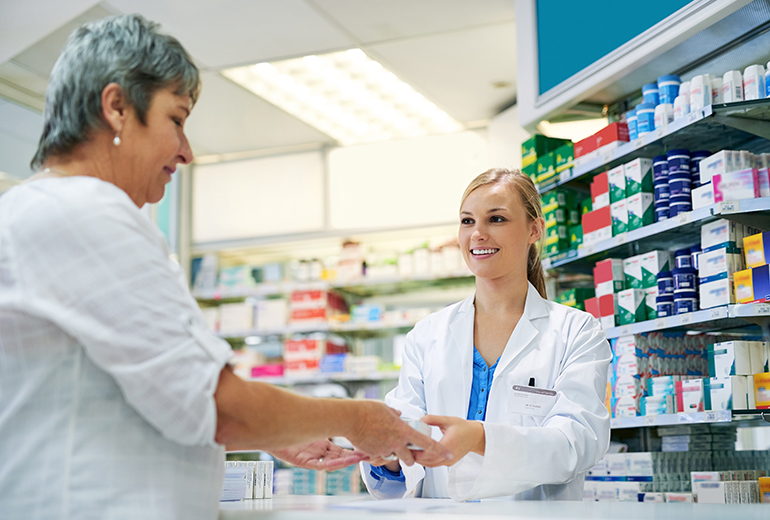 Apothekerin gibt Kundin Medikamente in die Hand