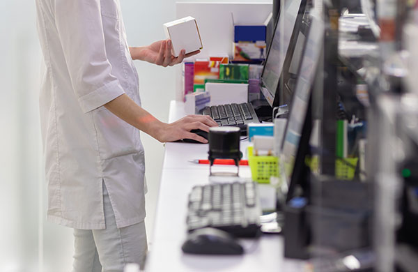 Apothekerin arbeitet im Backoffice am PC